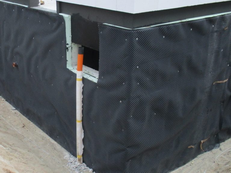 Kellerwand zur Prüfung Kellerwand zur Prüfung, gedämmt und mit schwarzer Plane abgedichtet, kleines Kellerfenster und Fallrohr