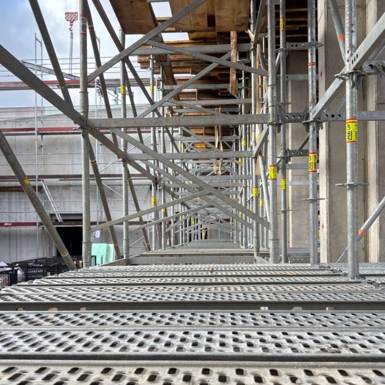 Baugerüst mit Blick durch die Verstrebungen entlang des Gebäudes während Vorbereitung Rohbauabnahme Raum Aschaffenburg