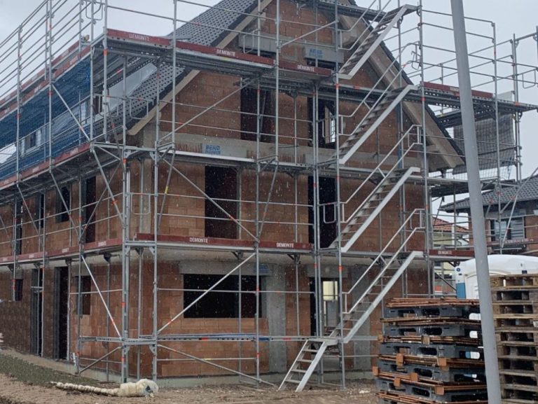 Rohbaupaket - Rohbau Doppelhaus Rohbau Doppelhaus zur Prüfung mit roten Ziegeln, schwarzgedecktes Dach, Gauben und Gerüst